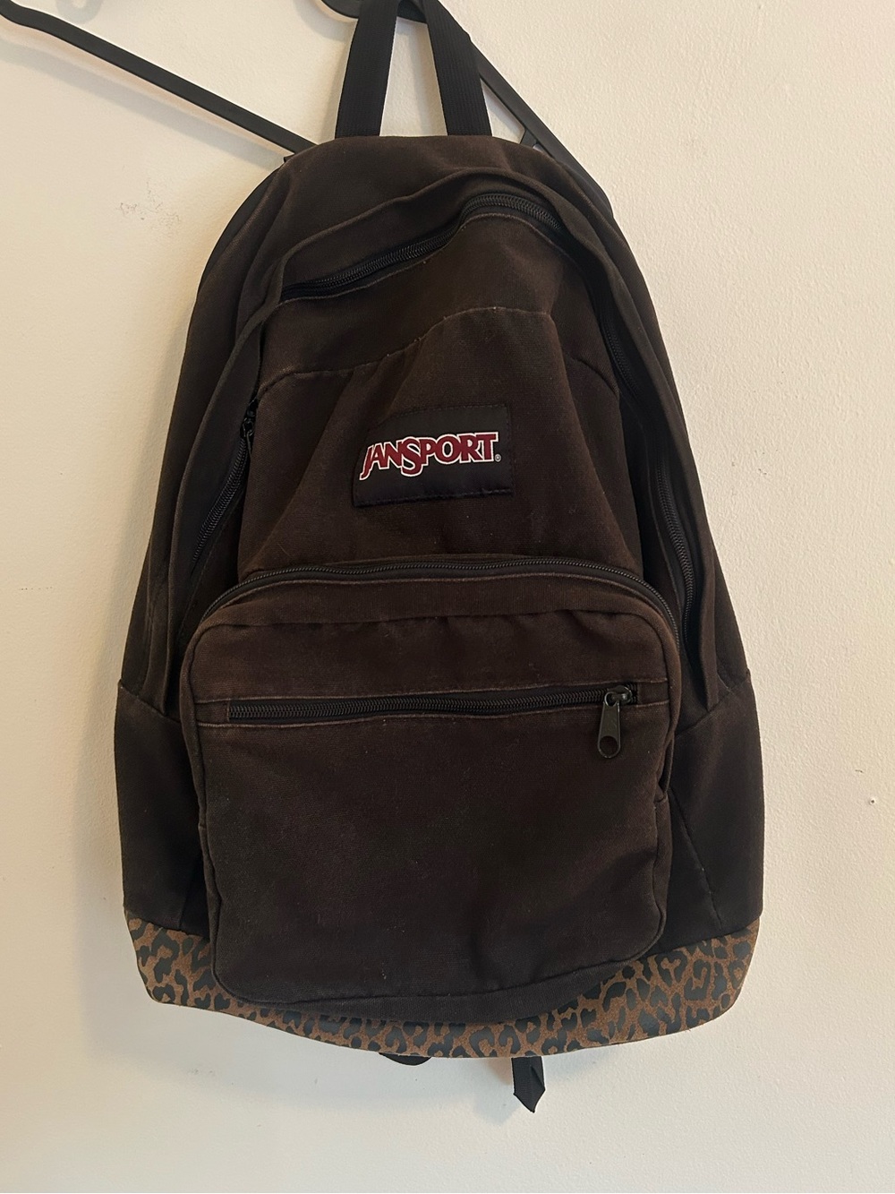 Brown Jansport back pack with a cheetah print suede bottom